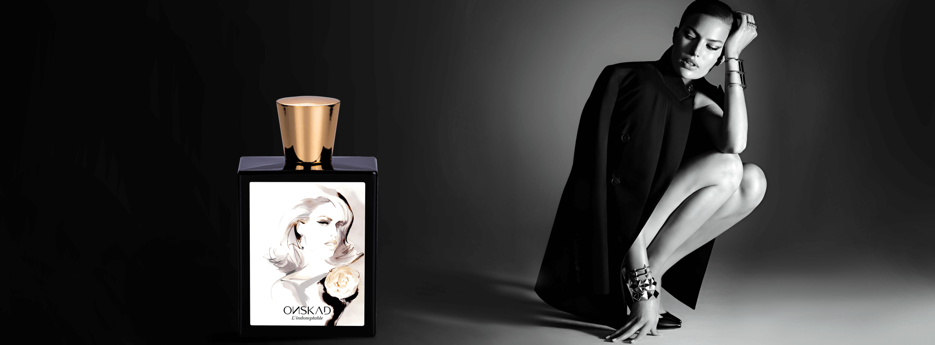Dieses Bild kombiniert einen Parfümflakon mit einem Model.Links ist ein eleganter, quadratischer Parfümflakon zu sehen. Der Flakon ist schwarz und mit einer farbigen Illustration einer stilisierten Frau mit zarten Gesichtszügen und ausdrucksstarkem Gesicht verziert. Der goldene Verschluss verleiht dem Flakon einen Hauch von Luxus.Rechts sitzt eine Frau in einem schwarzen Mantel. Das Foto ist in Schwarzweiß gehalten. Sie posiert dynamisch: Ein Bein ist angewinkelt, das andere ausgestreckt, was ihre schlanke Figur betont. Ihr Haar ist glatt zurückgekämmt. Ihr Blick ist leicht gesenkt, was eine nachdenkliche Stimmung erzeugt. Der Hintergrund ist ein Schwarzverlauf, der den Kontrast zum Parfümflakon und dem Model verstärkt.