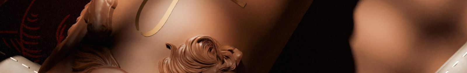Immagine di copertina che mostra in primo piano un flacone di profumo Hajine, dai riflessi marrone scuro, che lascia intravedere un ornamento traforato