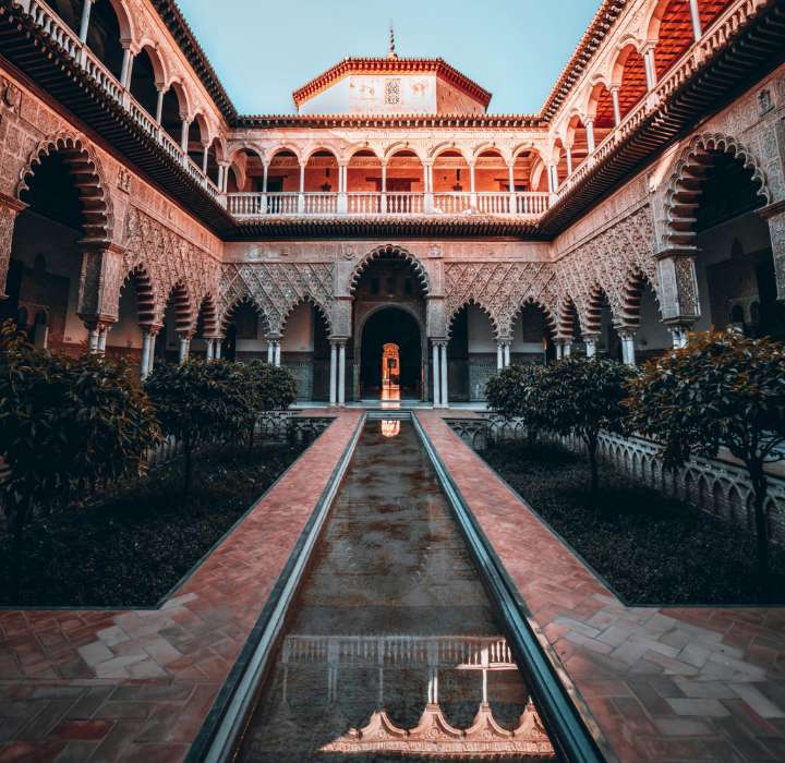 Binnenplaats van een Arabisch-Andalusisch paleis met hoefijzerbogen, zuilen en een centraal zwembad - luxe architectuur uit het Midden-Oosten