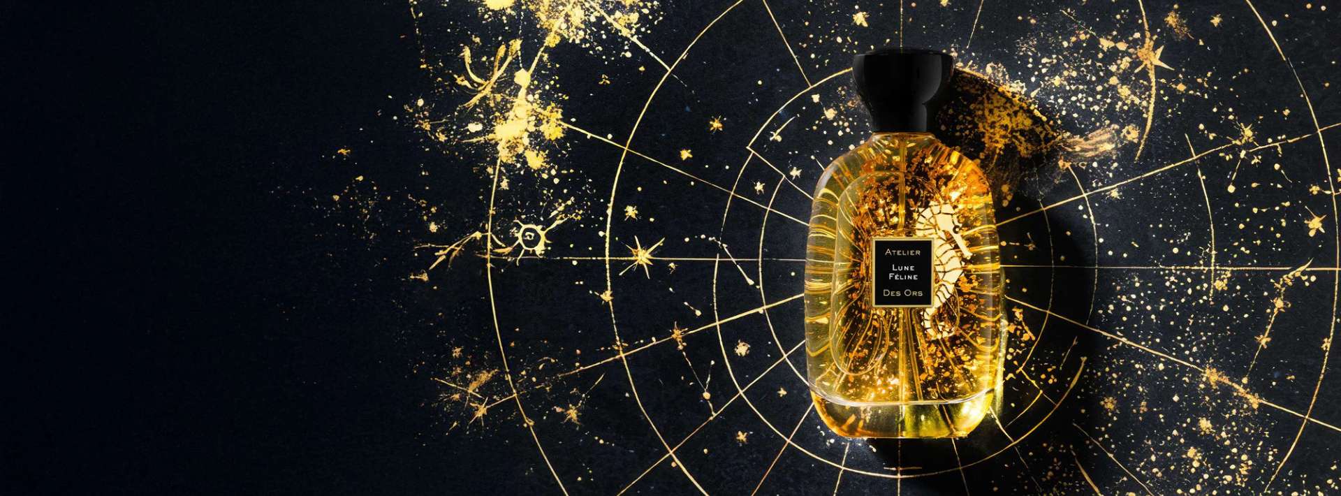 Un flacon de parfum en verre transparent, rempli d'un liquide doré, est placé sur un fond noir orné de motifs étoilés et dorés, formant un design cosmique