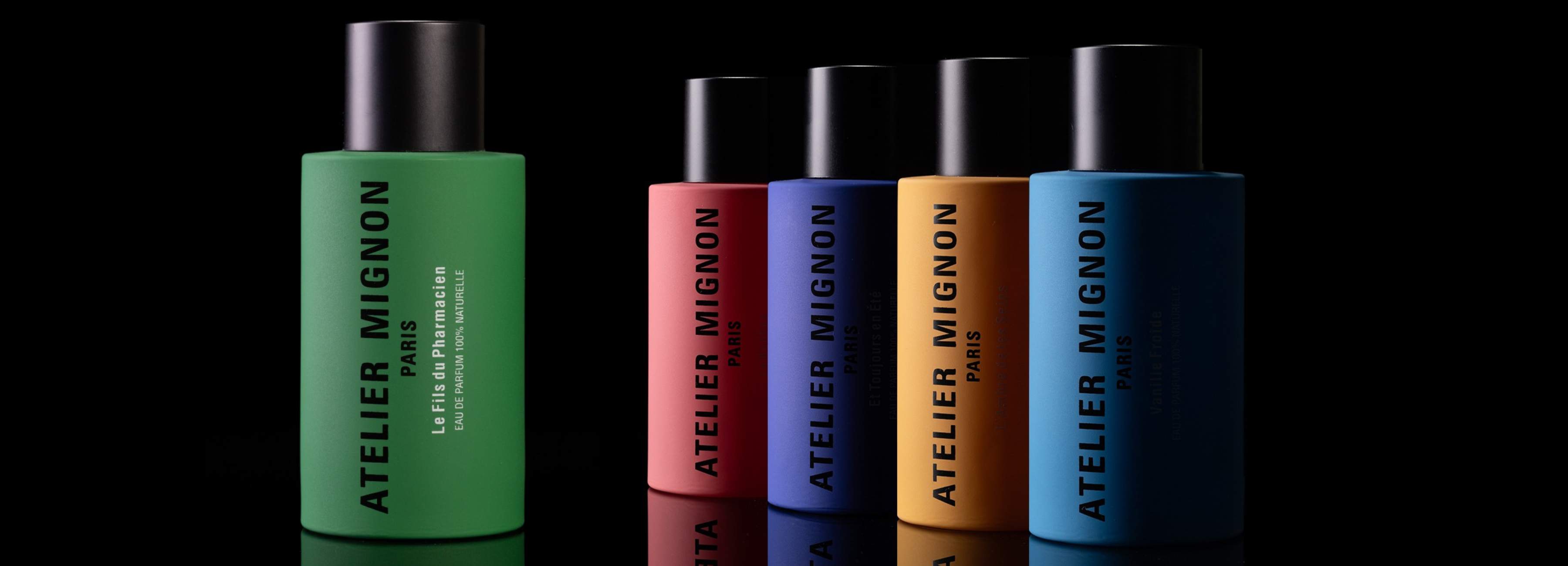 Das Bild zeigt eine Kollektion von Parfümflaschen, die jeweils eine zylindrische Form und ein elegantes Design haben. Die Flaschen sind in kräftigen Farben gehalten: grün, rosa, blau und orange. Jede Flasche hat einen schwarzen Deckel, der einen Kontrast zur leuchtenden Farbe des Körpers bildet.

Die Etiketten der Flaschen tragen den Text 