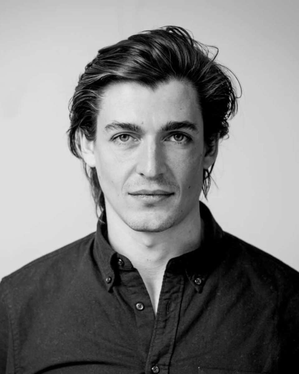 De afbeelding toont een man van voren, met een kalme, zelfverzekerde uitdrukking. Hij is parfumeur David Chieze. Hij heeft halflang, licht golvend bruin haar dat op zijn voorhoofd valt. Zijn gezicht is symmetrisch, met goed gedefinieerde gelaatstrekken: prominente jukbeenderen en een uitgesproken kaaklijn.

Hij draagt een donker overhemd, dichtgeknoopt tot aan de nek, wat zijn verzorgde uiterlijk nog meer accentueert. Zijn ogen zijn helder en doordringend en hij kijkt recht in de camera, wat een indruk van betrokkenheid geeft. De achtergrond is neutraal en onscherp, wat zijn gezicht en uitdrukking benadrukt.