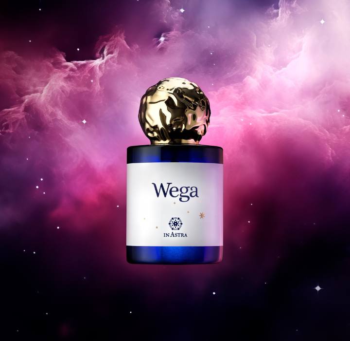 L'image représente un flacon de parfum élégant, qui semble flotter dans un environnement astral riche en couleurs. Le flacon a une base en verre de couleur bleu foncé et un capuchon orné d'une sphère dorée, qui donne une impression à la fois sophistiquée et moderne. Sur le flacon, le nom
